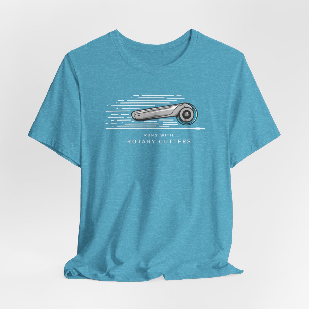 A Heather Aqua T-shirt featuring minimalist graphic of a sleek rotary cutter in motion with speed lines. Text below reads "RUNS WITH ROTARY CUTTERS" in a modern font.