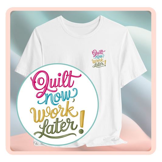 A funny quilting T-shirt featuring bold, stylized text that reads "Quilt Now, Work Later" in various vibrant colors. The playful design captures the spirit of passionate quilters who prioritize their craft over other responsibilities.